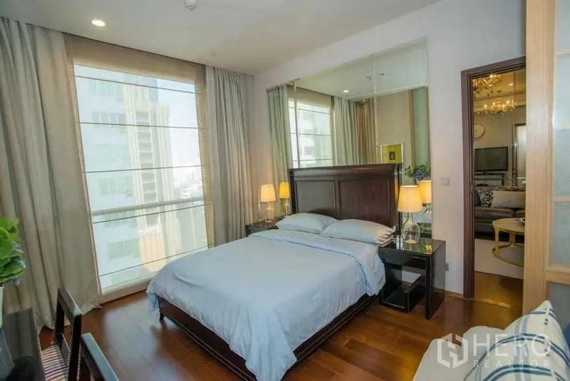 คอนโด ให้เช่าในWatthana, Bangkok - ห้องนอนรับแสงธรรมชาติ พื้นไม้ เตียงไม้สีเข้ม และผนังกระจกเหนือหัวเตียง