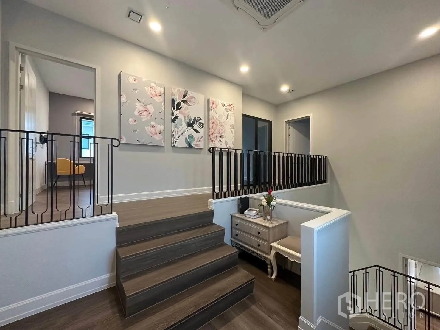 Detached House for rent in Saphan Sung, Bangkok - Upper hallway with artwork, dark railings, and recessed lighting.