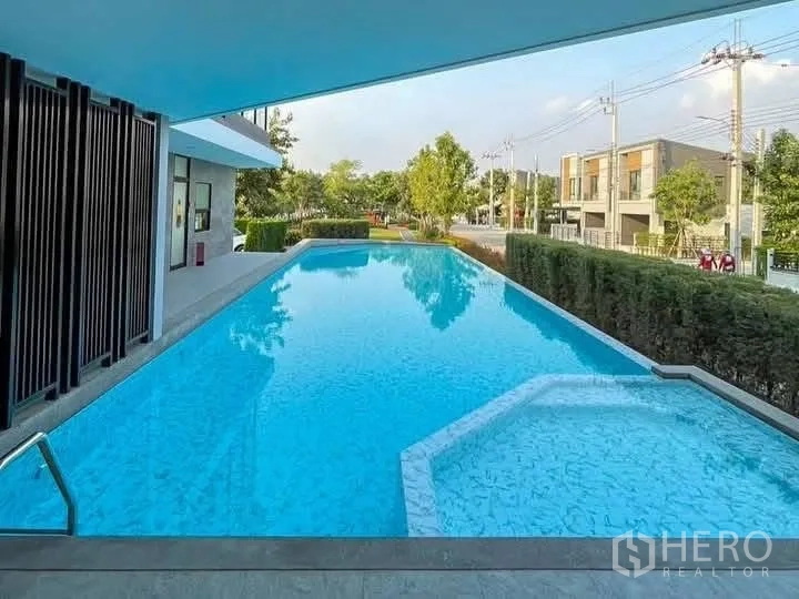 ทาวน์เฮาส์ for rent in Bang Phli, Samut Prakan - สระว่ายน้ำกลางแจ้งข้างคลับเฮาส์ มองเห็นถนนและต้นไม้