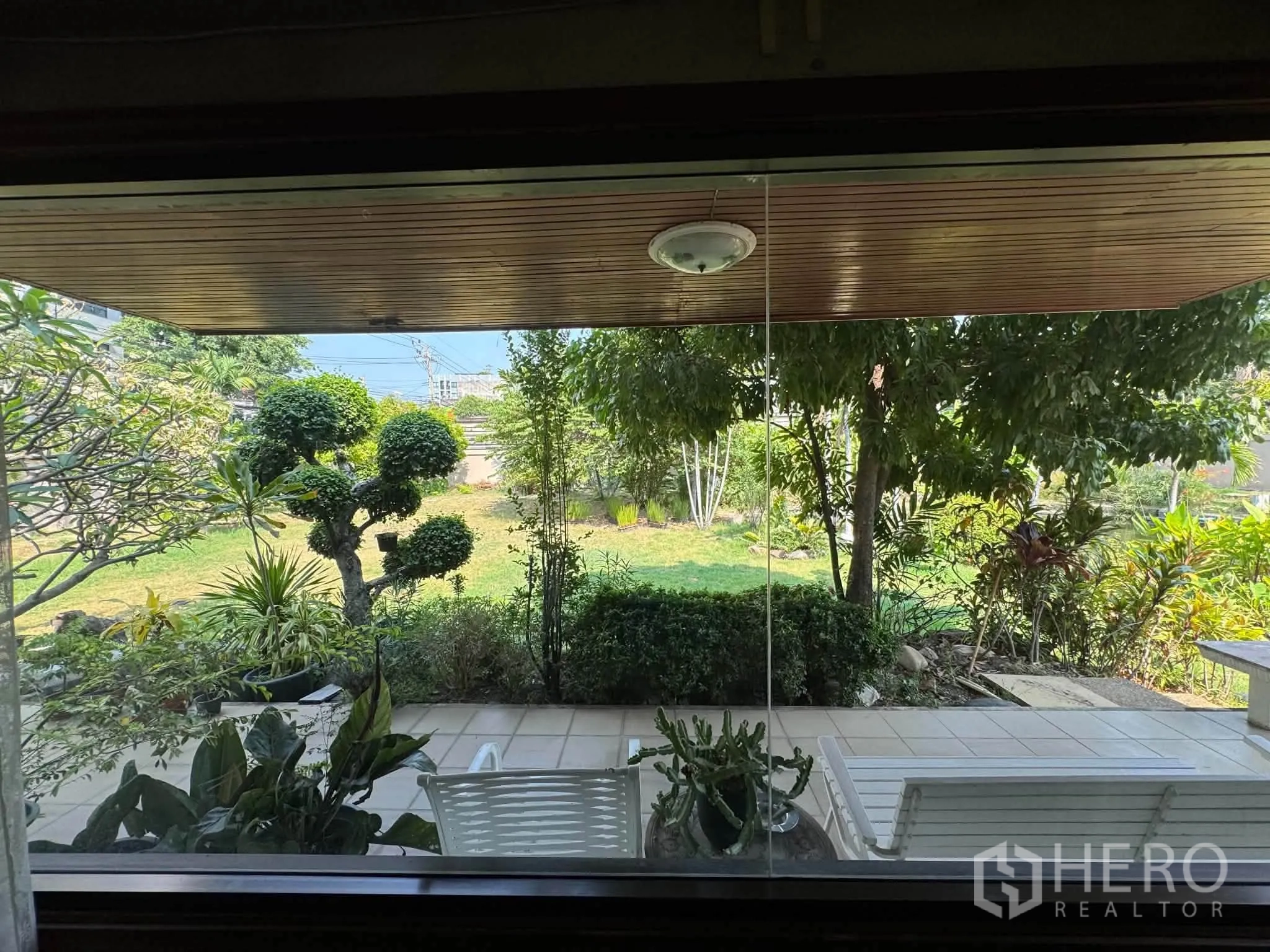 บ้านเดี่ยว for rent or sale in Mueang Samut Prakan, Samut Prakan - มุมมองสวนและชานระเบียงจากหน้าต่างบานใหญ่ภายในบ้าน