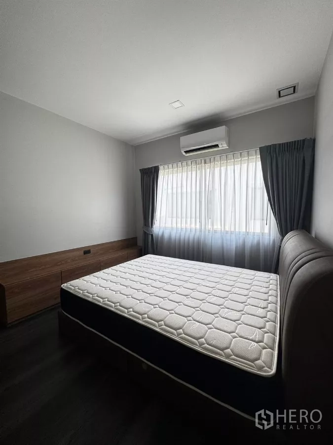 联排别墅 出租在Bang Phli, Samut Prakan - 明亮次卧，配床、大窗与空调。