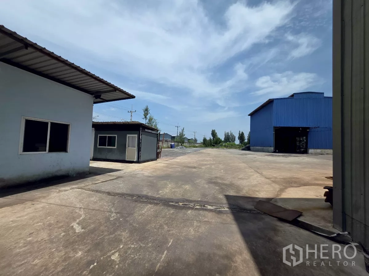 โรงงาน ให้เช่าในMueang Samut Sakhon, Samut Sakhon - ลานคอนกรีตขนาดใหญ่สำหรับรถบรรทุก ระหว่างอาคารภายในพื้นที่และโกดังสีน้ำเงิน