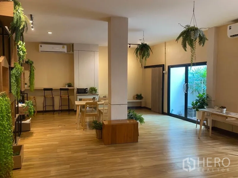 Retail Space for rent in Khlong Toei, Bangkok - Open-plan retail interior with wood flooring, hanging ferns, bar seating and sliding glass doors.