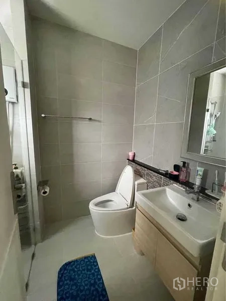 独立式住宅 出售在Lat Krabang, Bangkok - 瓷砖浴室，洗手台、镜子与马桶，旁有淋浴区。