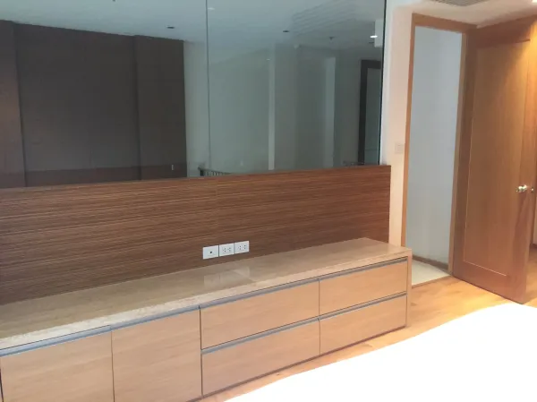 คอนโด ให้เช่าในSathon, Bangkok - มุมห้องนอนพร้อมตู้บิลท์อินลายไม้และผนังกระจก ใกล้ประตูห้องน้ำ