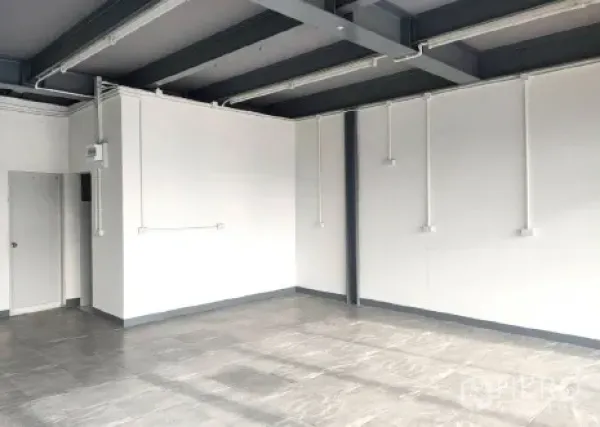 Retail Space for rent in Khlong Toei, Bangkok - Bright corner of the retail space with tiled floor, white walls and a side door.