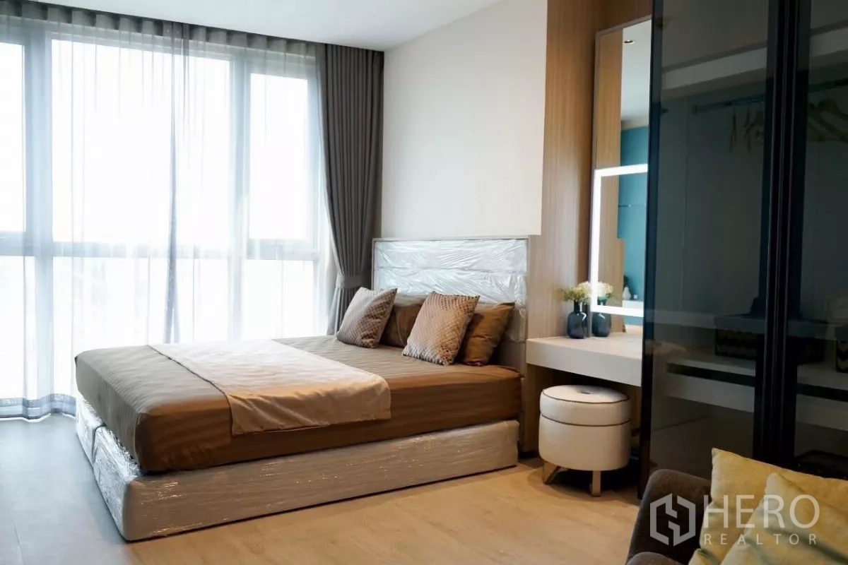 公寓 出租在Watthana, Bangkok - 主卧配大床、纱帘、带灯梳妆台和嵌入式衣柜。