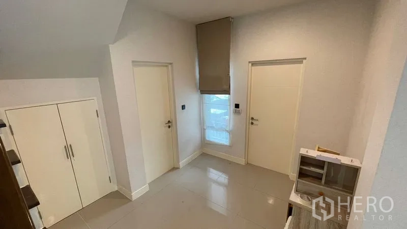 Detached House for rent in Bang Kapi, Bangkok - Ground floor hallway with under-stair storage and two white doors.