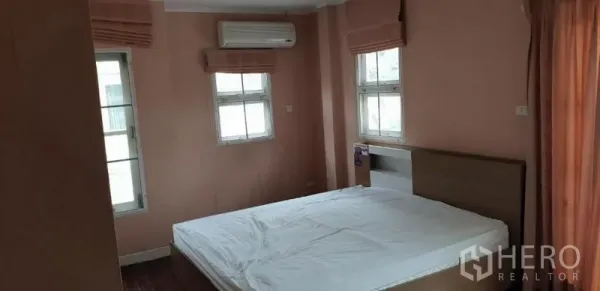 独立式住宅 出租在Phra Khanong, Bangkok - 温馨卧室，桃色墙面，床铺，多扇窗户与窗帘，壁挂空调。