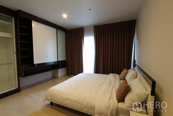 Condominium for rent in Watthana, Bangkok - Second bedroom with double bed, large closet and floor‑to‑ceiling curtains.