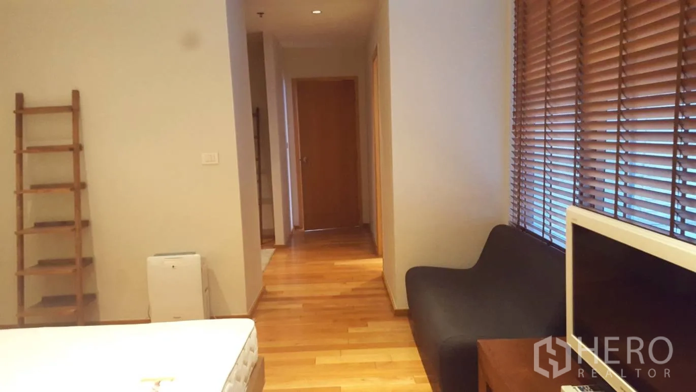 Condominium for rent or sale in Khlong Toei, Bangkok - Bedroom corner with large window blinds, hallway and a TV console.