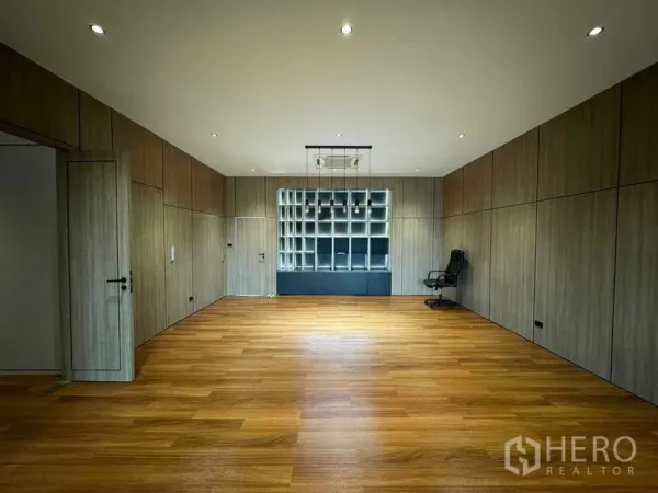 Home Office for rent or sale in Bang Phli, Samut Prakan - Large office room with built‑in shelving wall and warm wooden floors.