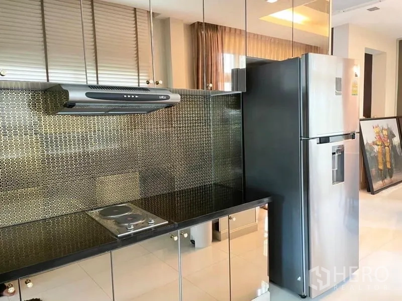 Detached House for sale in Lat Krabang, Bangkok - Kitchen counter with hob, hood and mirrored cabinets providing ample storage.