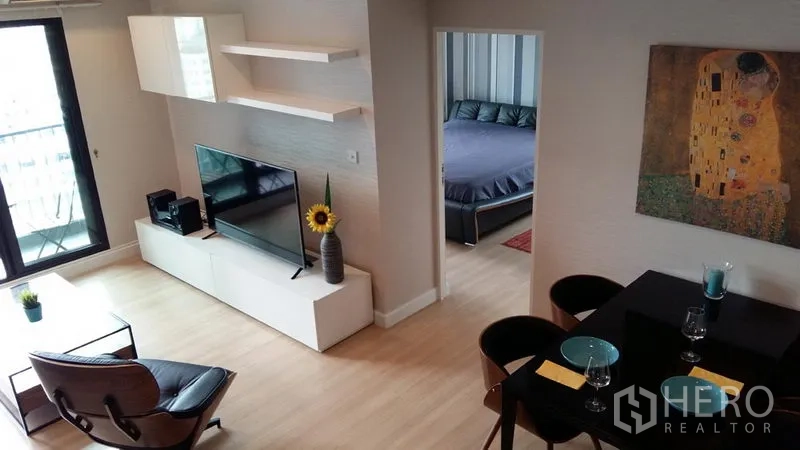 公寓 出租在Sathon, Bangkok - 从餐区望向客厅与卧室的开放式布局，电视柜与茶几可见。