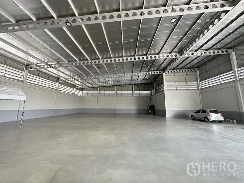 Factory for rent or sale in Lam Luk Ka, Pathum Thani - High-clear warehouse with insulated metal roof and perforated steel beams.