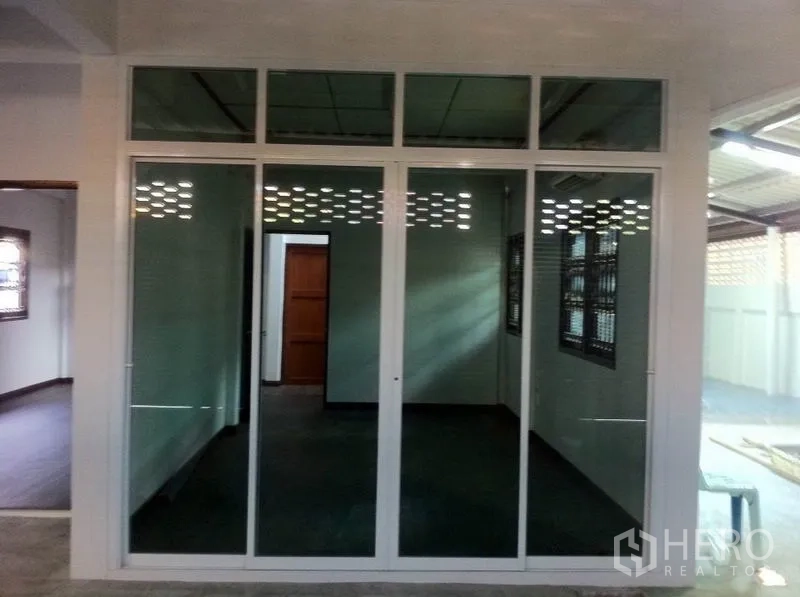 Warehouse for rent in Lam Luk Ka, Pathum Thani - Glass-partitioned office room with sliding doors and air conditioning.