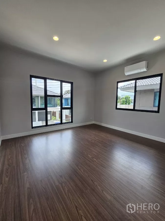 Detached House for sale in Lam Luk Ka, Pathum Thani - Corner bedroom upstairs with two windows and air conditioner.