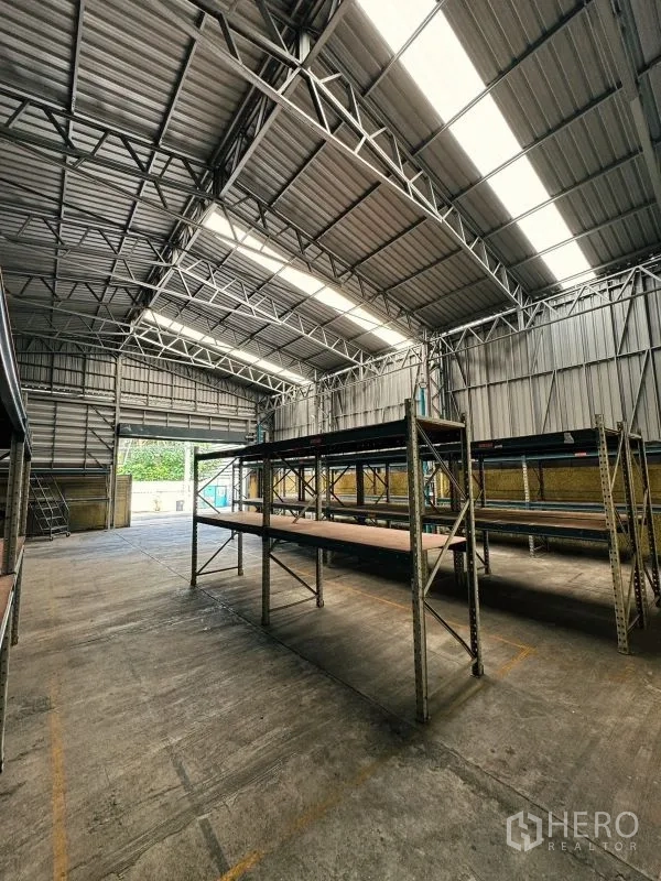 货栈 出租在Din Daeng, Bangkok - 内部视角，货架系统与大型卷帘门，屋顶采光板明显。