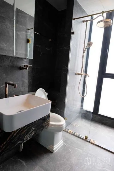 Condominium for sale - Bright bathroom with glass shower enclosure and window.