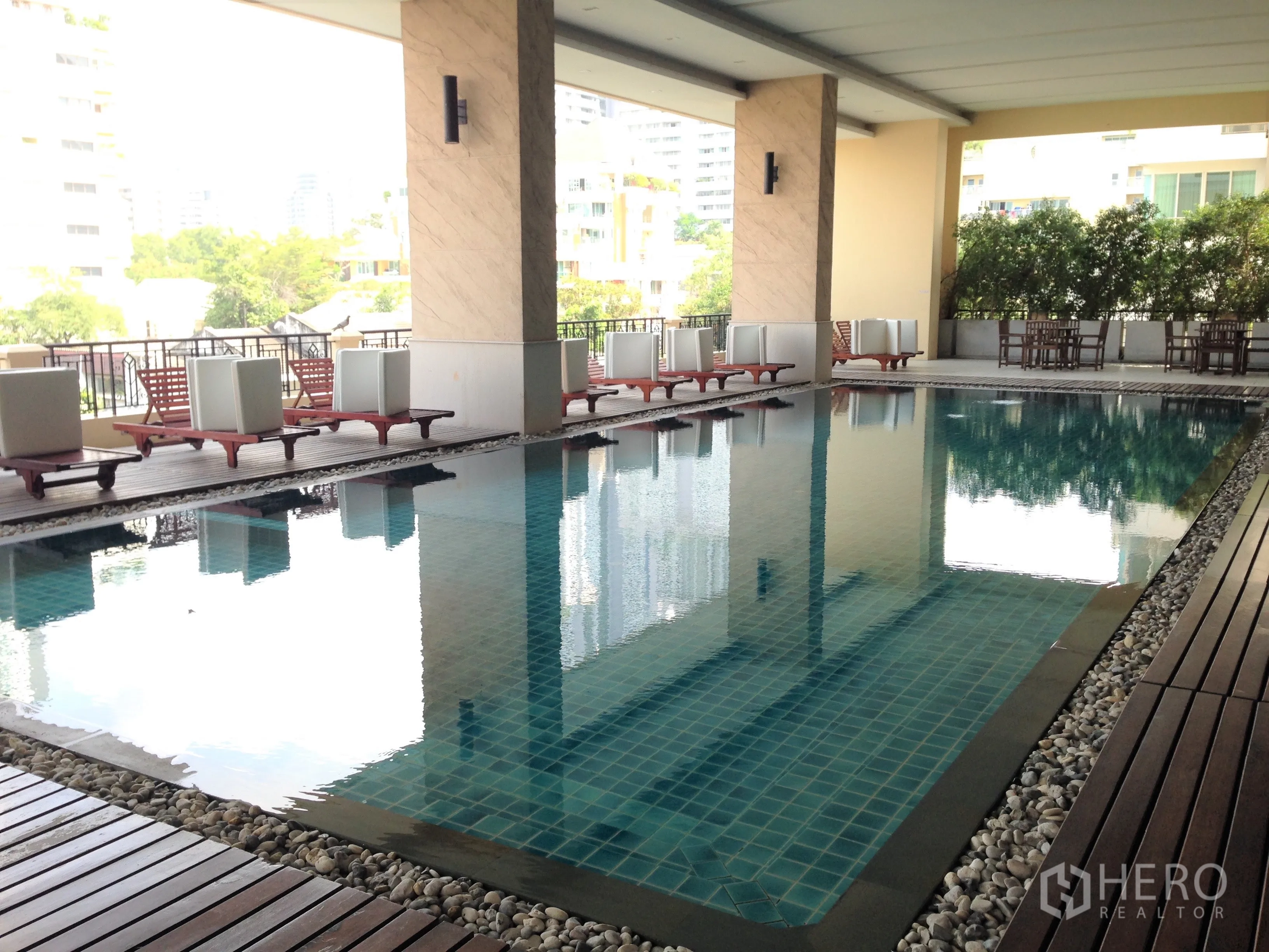 公寓 出租或出售在Watthana, Bangkok - 公寓住户泳池，半室内设计，配躺椅与景观木平台。