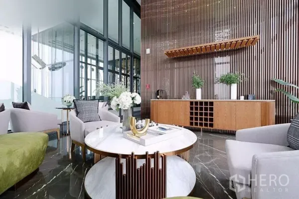 Condominium for rent in Watthana, Bangkok - Sophisticated sky lounge with marble floors, wood slat wall, round coffee table and glass walls in a Bangkok condo.