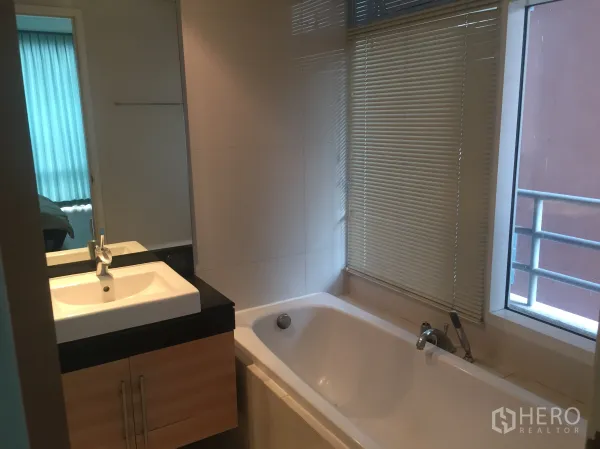 公寓 出租或出售在Watthana, Bangkok - 带长浴缸的浴室，窗边百叶与洗手台