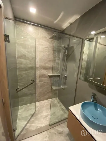 公寓 出租或出售在Watthana, Bangkok - 现代卫浴，玻璃干湿分离淋浴间与蓝色面盆。