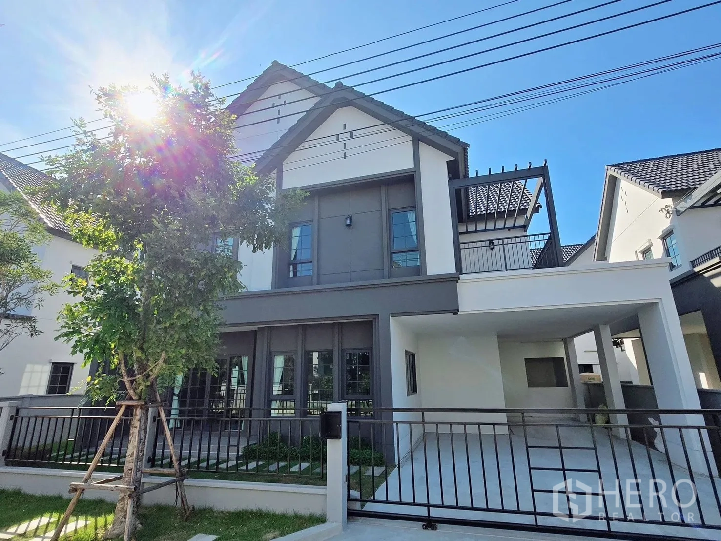 Detached House for rent or sale in Bang Phli, Samut Prakan - Modern two‑storey detached house exterior with gable roof, covered carport and gated yard.