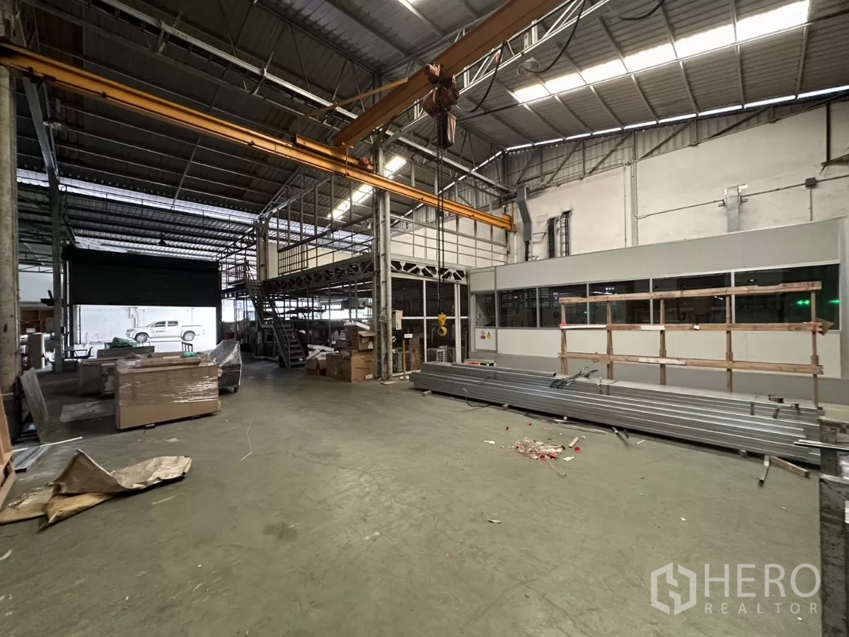 Warehouse for rent in Yan Nawa, Bangkok - Open bay with crane rails, roller door and a modular office unit.