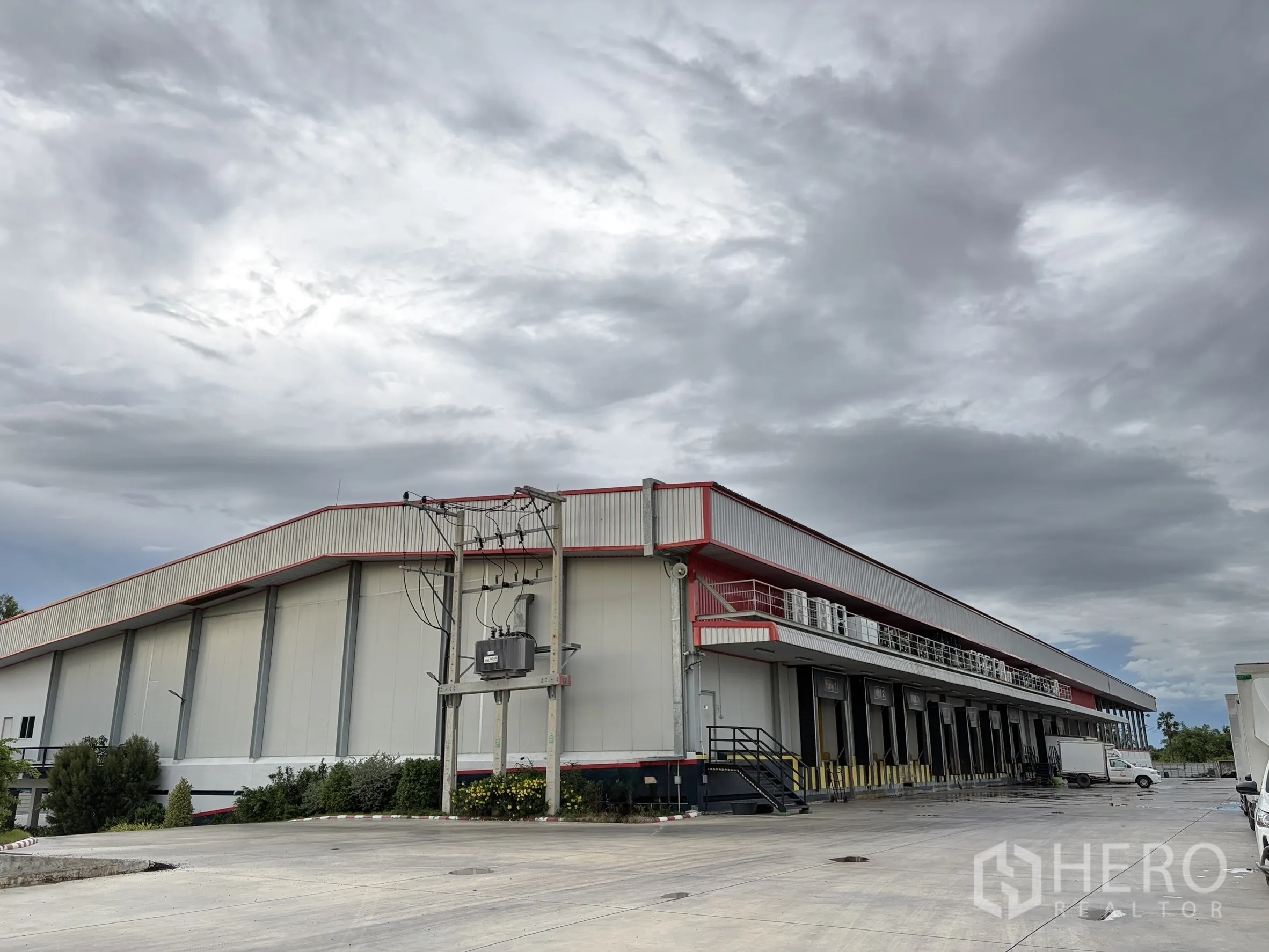 Factory for sale in Mueang Nakhon Pathom, Nakhon Pathom - Wide view of large factory building with dock doors and transformer.