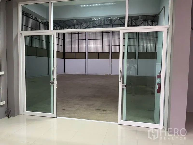 คลังสินค้า ให้เช่าในBang Kapi, Bangkok - ประตูกระจกบานคู่เปิดจากออฟฟิศสู่พื้นที่โกดังเพดานสูง