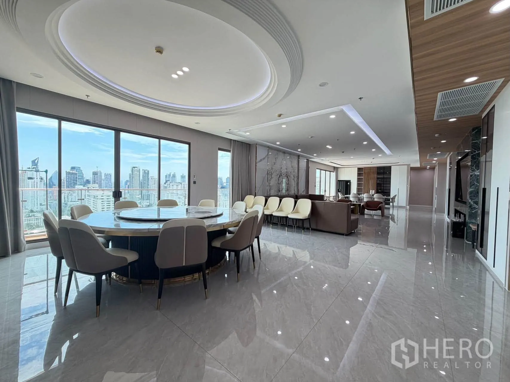 Condominium for sale in Watthana, Bangkok - Expansive open-plan living and dining area with round table and skyline views.