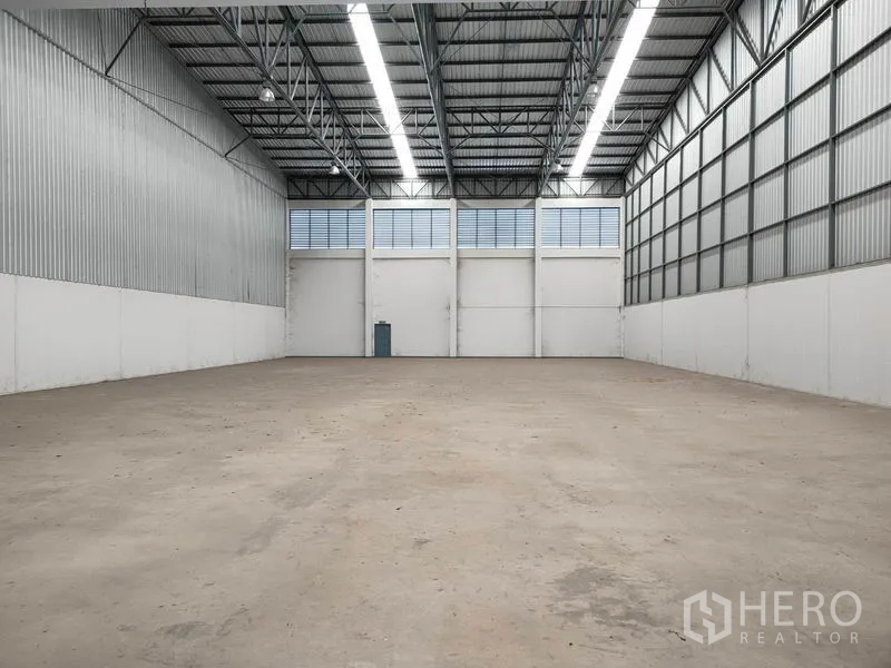 Factory for rent in Phra Nakhon Si Ayutthaya - Empty warehouse bay showing high roof lights, ventilation panels and clear open floor.