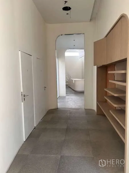 Standalone for rent in Khlong Toei, Bangkok - Hallway with shelving and two service doors leading to back-of-house areas.