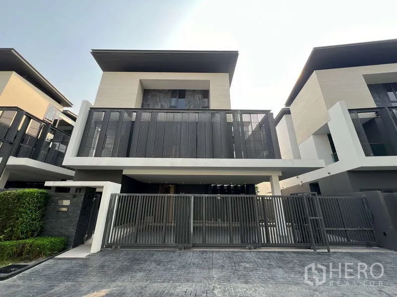 Detached House for rent in Suan Luang, Bangkok - Front elevation of the detached house with wide sliding gate and carport.