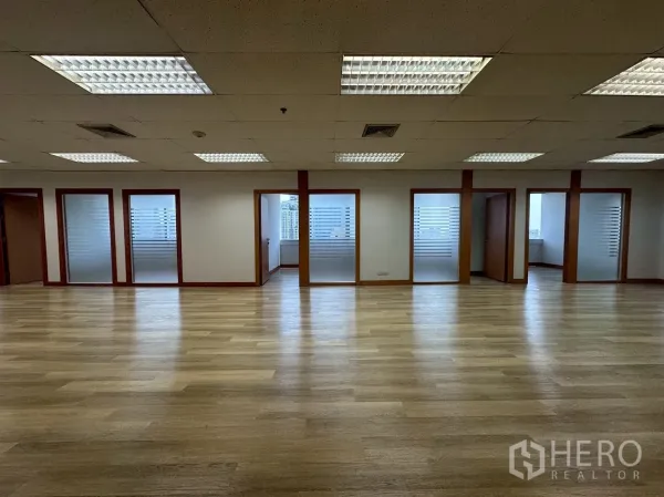 Office Space for rent - Front view of meeting rooms and offices with frosted glass panels beside a large workspace.