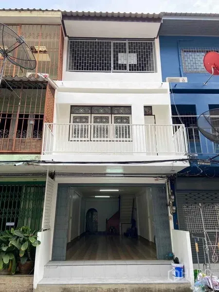 Shophouse for sale in Phra Khanong, Bangkok - Three-storey shophouse facade with front balcony, safety grilles and a wide roll-up storefront near BTS Bang Chak.