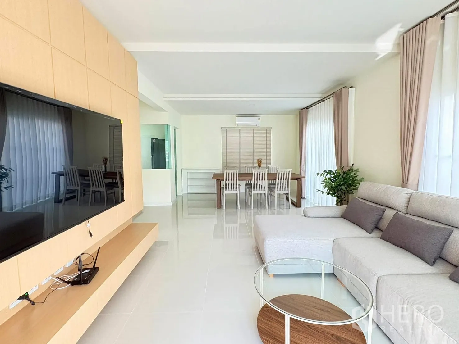 บ้าน for rent in Bang Phli, Samut Prakan - มุมกว้างโถงนั่งเล่นเชื่อมถึงห้องทานอาหาร พร้อมหน้าต่างบานใหญ่และต้นไม้ในกระถาง
