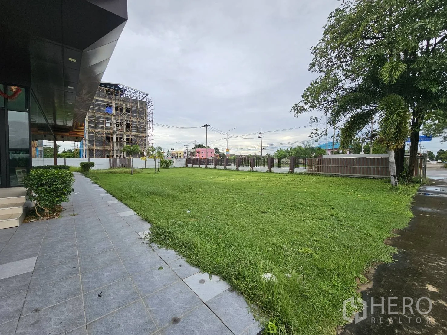 Warehouse for rent in Lam Luk Ka, Pathum Thani - Landscaped lawn and footpath beside the glass-front office building.