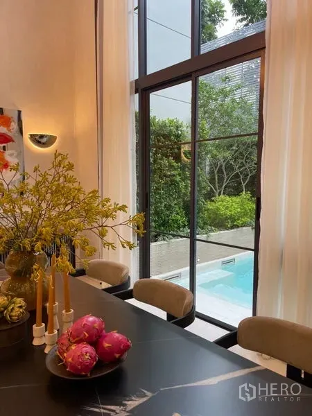 Detached House for sale in Suan Luang, Bangkok - Bright dining area with floor-to-ceiling windows opening to a private pool and landscaped garden.