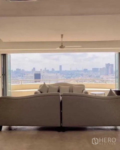 Condominium for rent in Khlong San, Bangkok - Sofa seating facing an expansive balcony with skyline panorama.