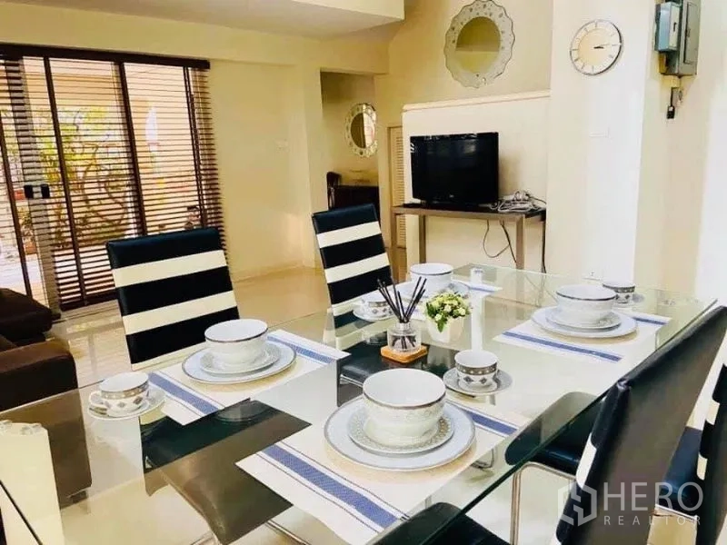 Detached House for rent in Watthana, Bangkok - Glass-top dining table set for four beside sliding doors in a modern Bangkok home.