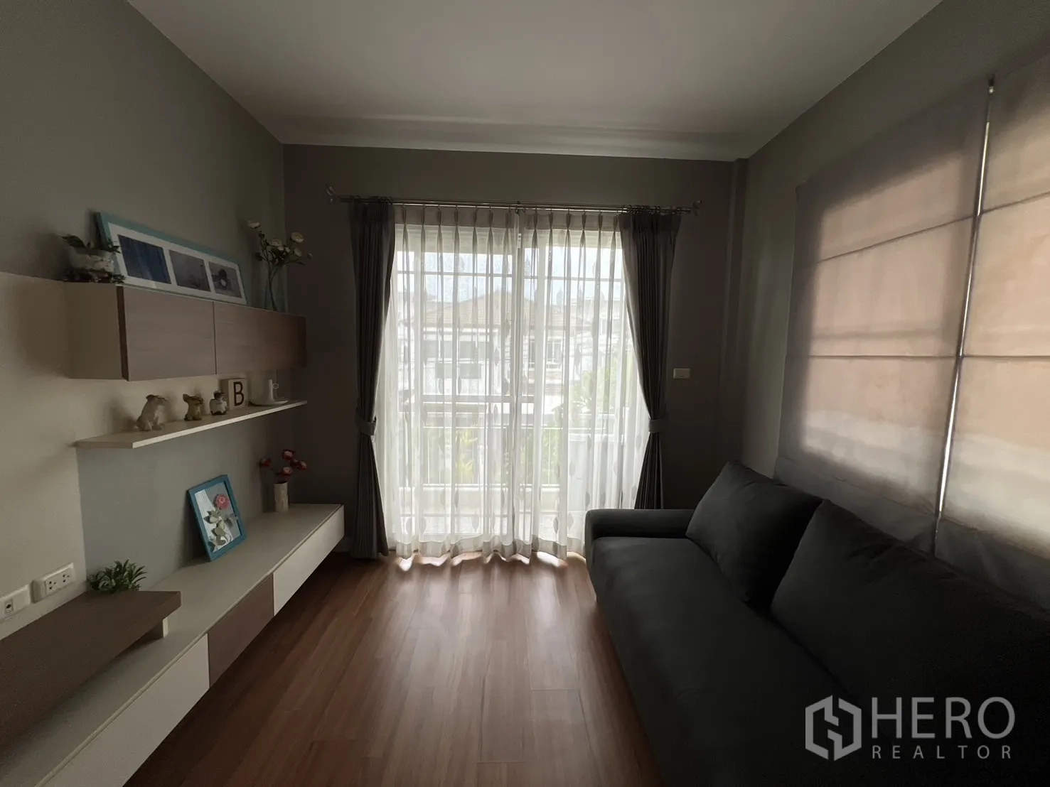 Detached House for rent in Bang Kapi, Bangkok - Upstairs family room with sofa, built-in shelves and balcony doors.