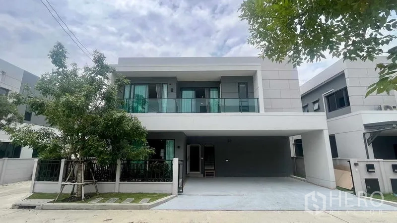 บ้าน ให้เช่าในBang Phli, Samut Prakan - มุมมองด้านหน้าบ้านสไตล์ร่วมสมัย พร้อมทางรถเข้าและต้นไม้ให้ร่มเงา