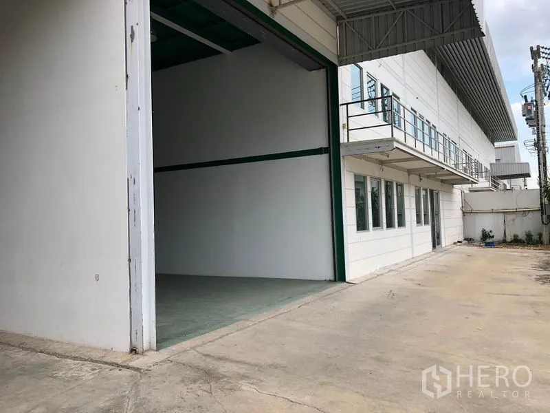 工厂 出租在Lam Luk Ka, Pathum Thani - 建筑侧宽阔装卸场地，配卷帘大门便于卡车进出