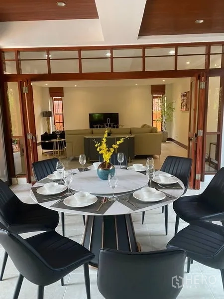 Detached House for rent in Suan Luang, Bangkok - Open dining room flowing to a family lounge with sectional sofa and TV.