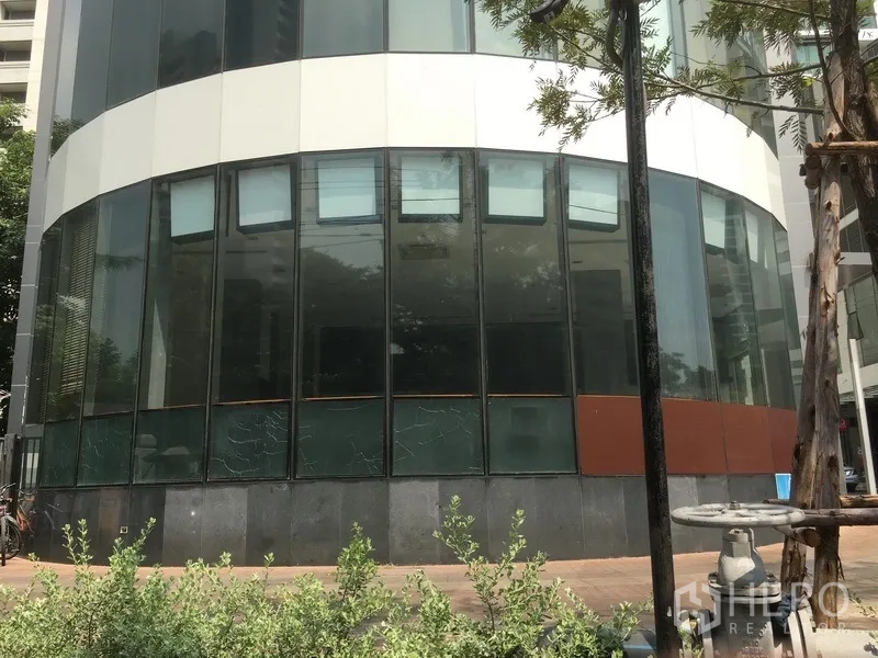 Retail Space for rent in Khlong Toei, Bangkok - Curved glass-fronted ground-floor retail unit with tall windows and landscaped walkway in Phrom Phong.