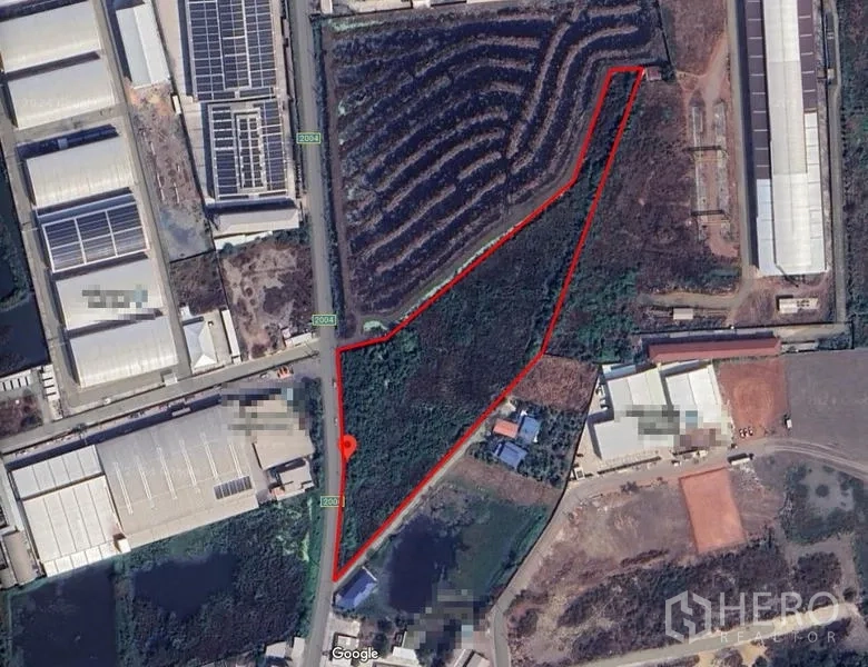 Land for sale in Mueang Samut Sakhon, Samut Sakhon - Aerial view with a red outline marking an irregular-shaped land parcel amid factories.