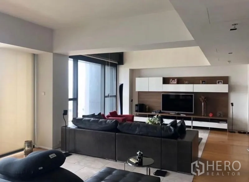 Condominium for rent in Sathon, Bangkok - Open-plan lounge with large sofa, TV console and balcony access