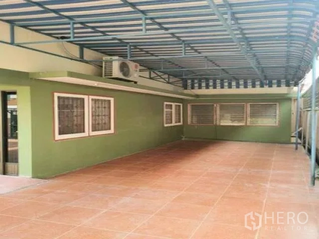 带办公室的家 出租在Wang Thonglang, Bangkok - 覆盖式车棚区域，绿色外墙，带防盗窗和赤陶地砖